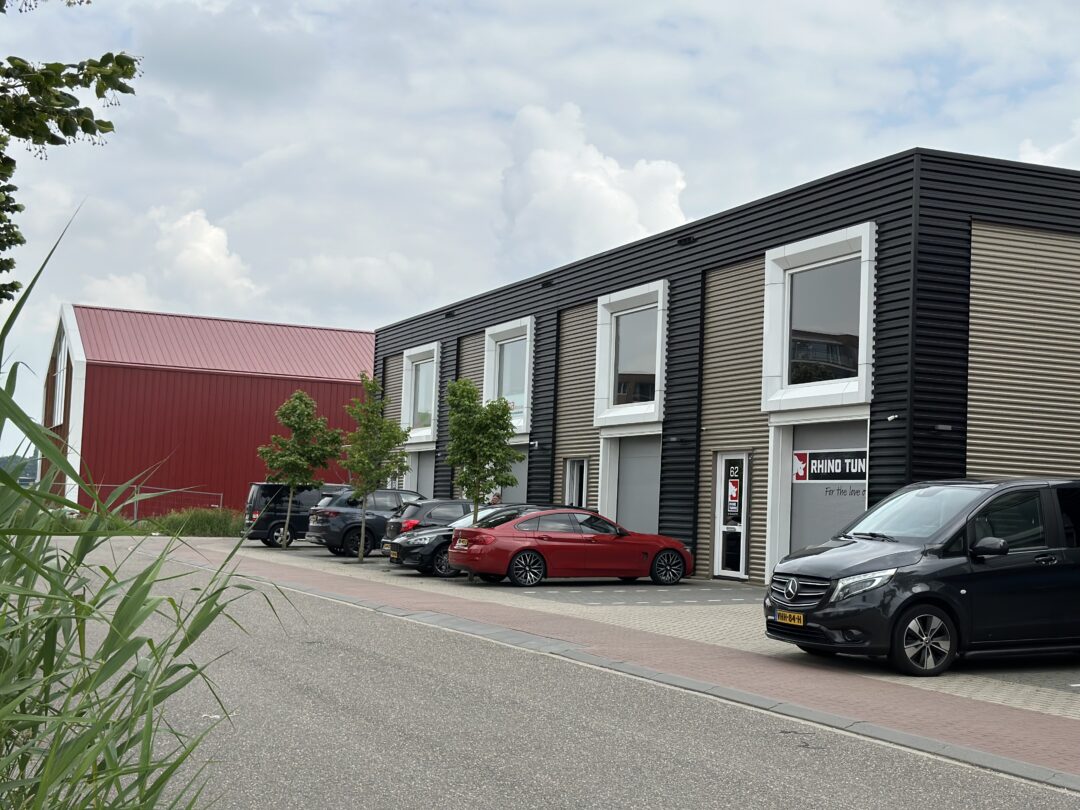 Bedrijvengebouwen met auto's ervoor geparkeerd.